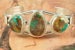 Genuine Royston Turquoise set in Sterling Silver Bracelet. Created by Navajo Artist Lucy Valencia. Signed L. J. by the artist.The Royston Turquoise Mine was originally known as the Royal Blue Mine. It produces Turquoise that has a mixture of blues and greens in the same formation. The Royston Turquoise Mine is located in Nye County, Nevada. 